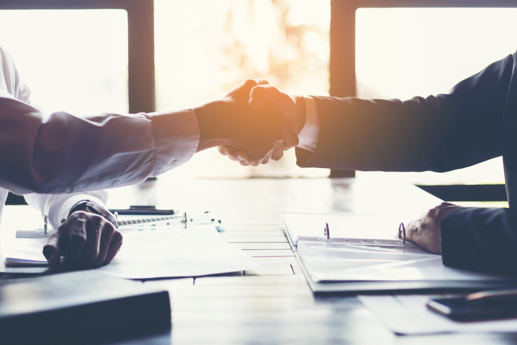 business partners handshaking after business success negotiation at meeting room. Insurance